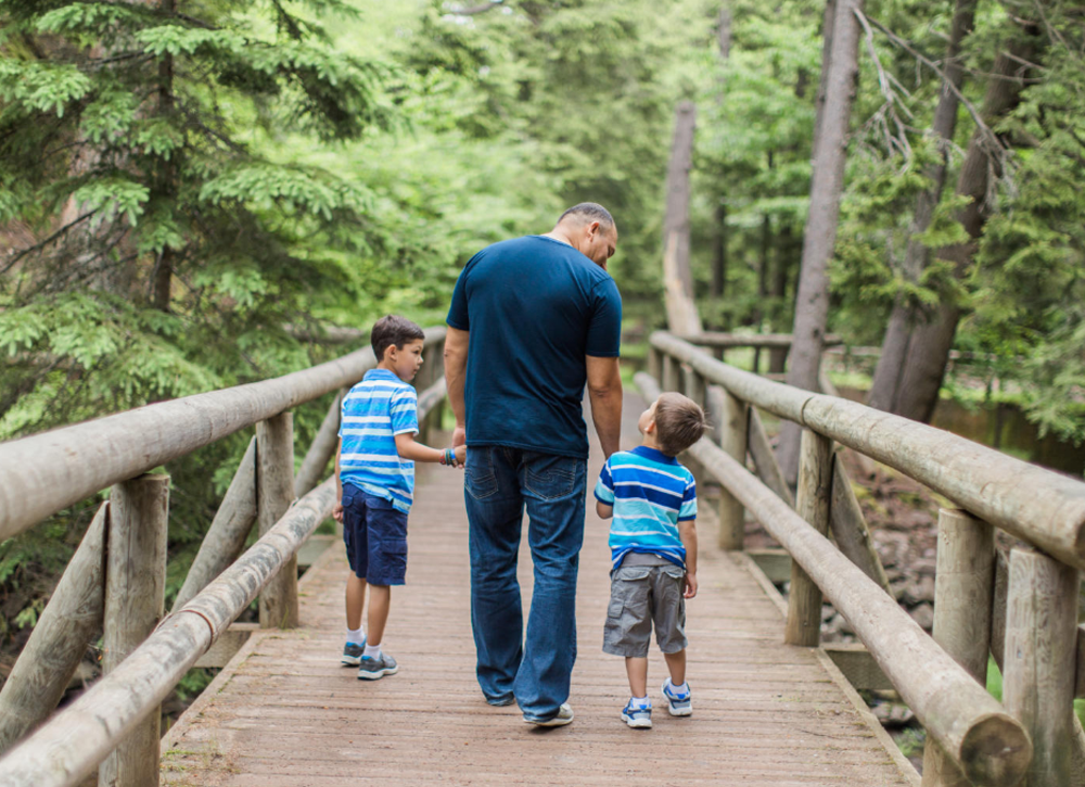 Father walking with sons on a trail