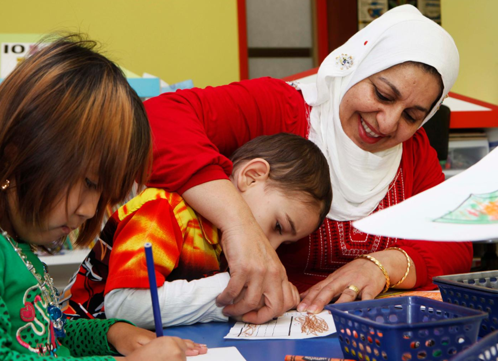 Child care worker and children doing crafts