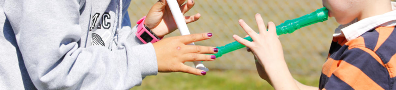 Child care worker teaching a child to play the recorder