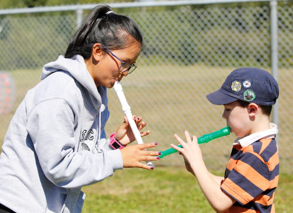 Child care worker teaching a child to play the recorder
