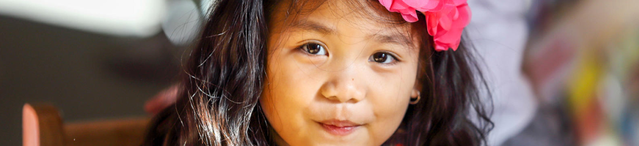 Little girl with a pink bow in her hair.
