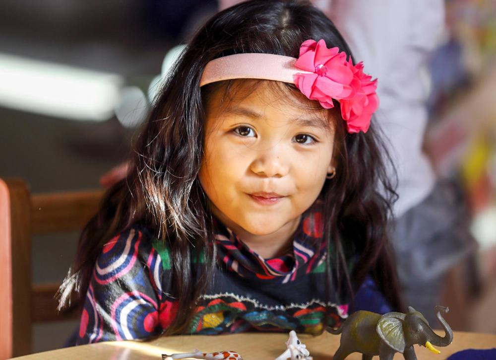 Little girl with a pink bow in her hair.