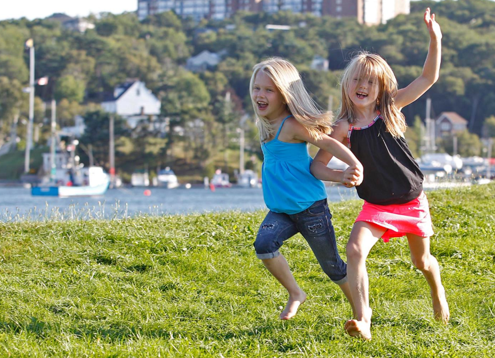 Two young girls running in a field